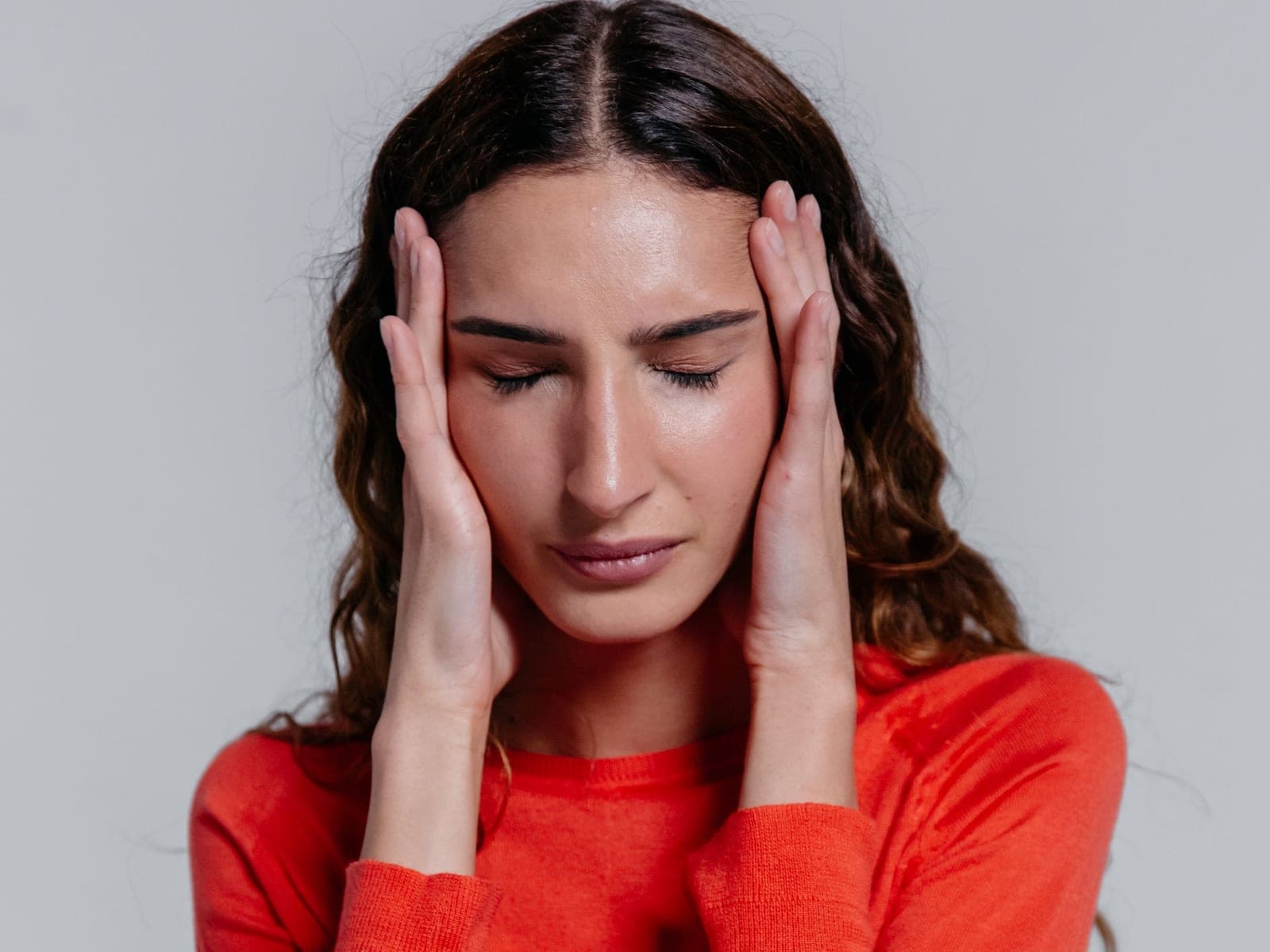 A woman pressing her fingers to her temples
