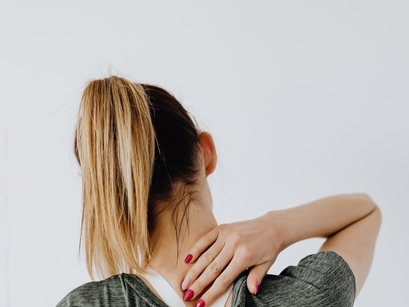 A woman holding the back of her neck