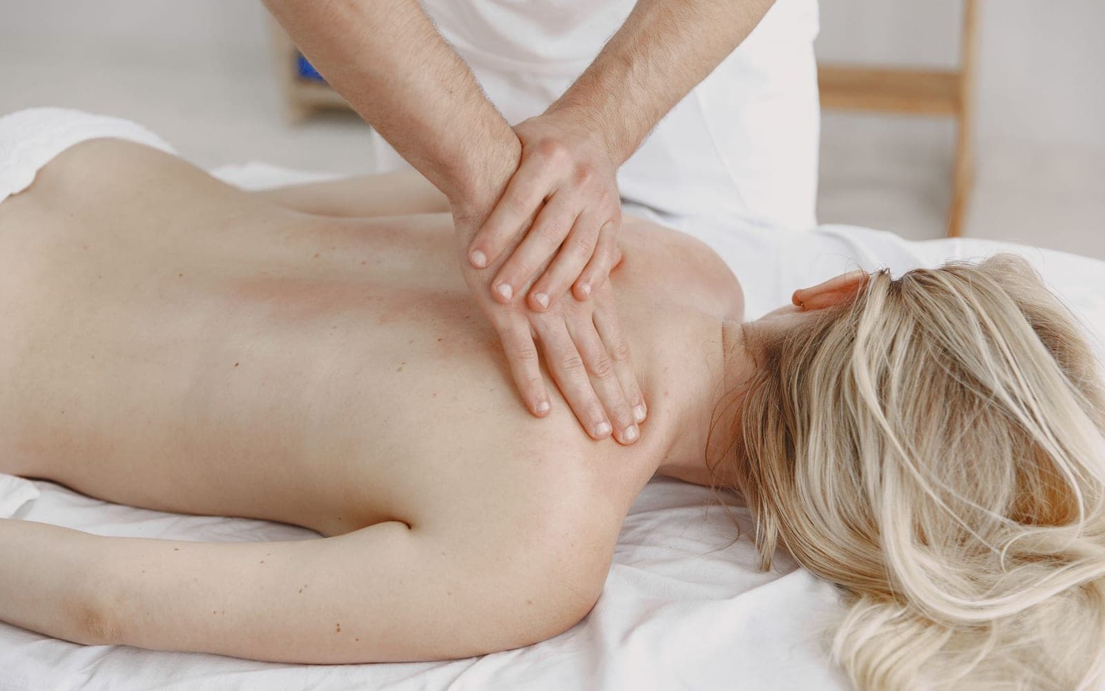 A woman receiving a back massage on a treatment table