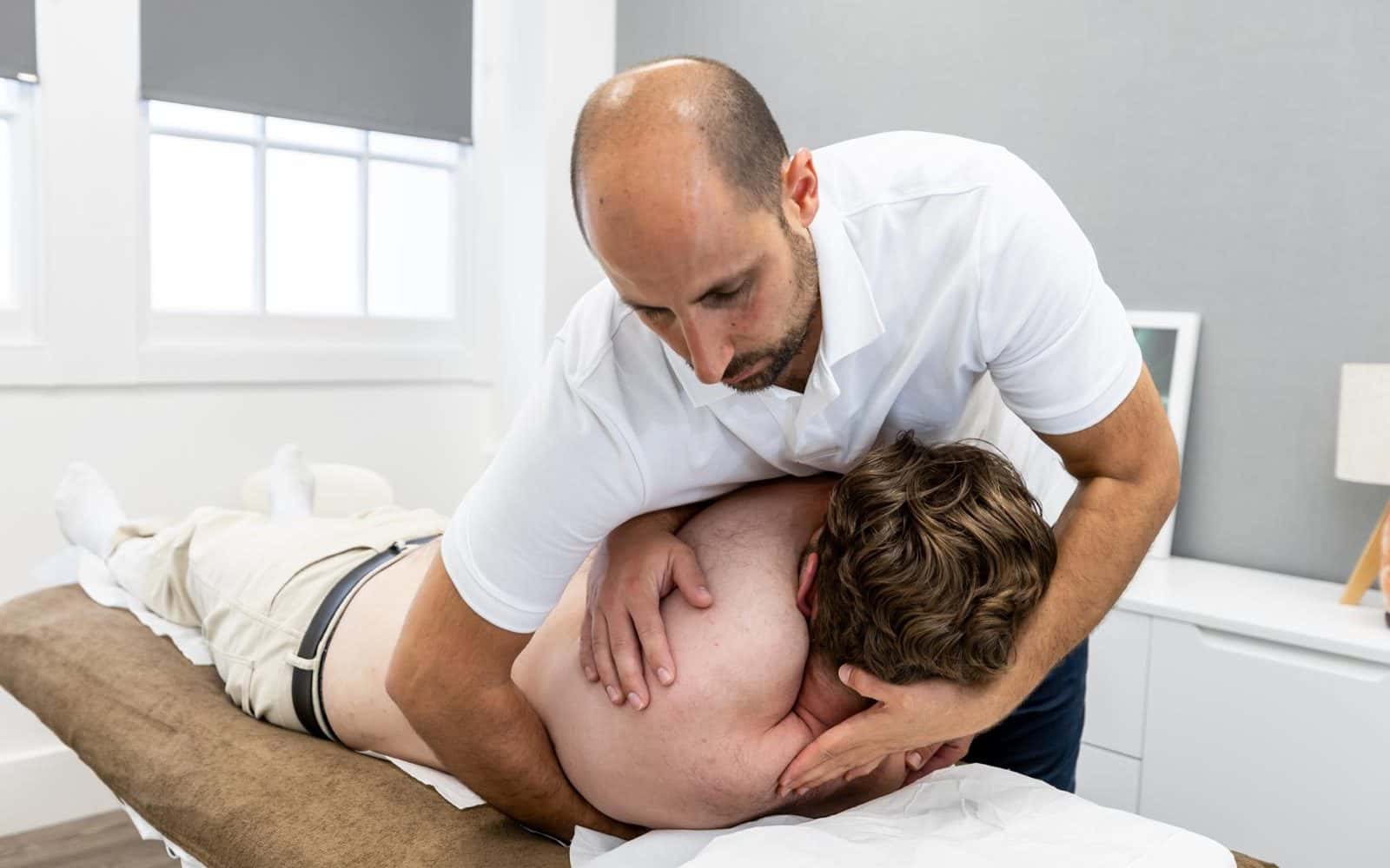 Abdul Abu-Laban treating a patient's neck and shoulder at the clinic in Bridge of Don