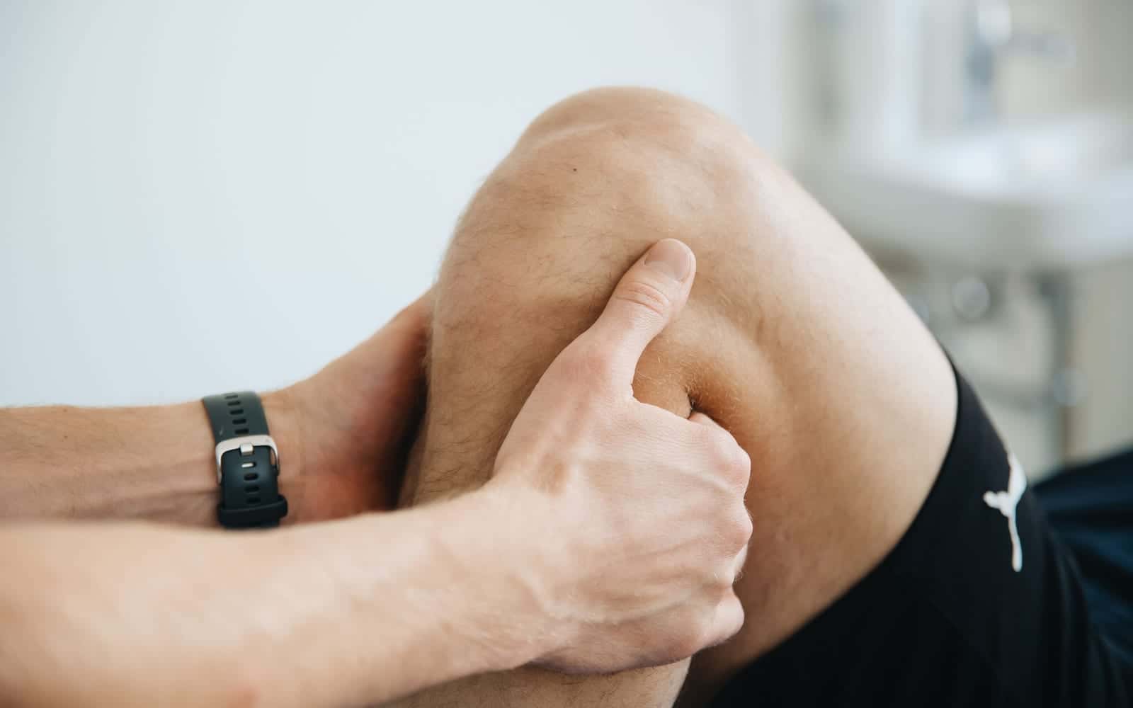 A therapist massaging a runner's knee