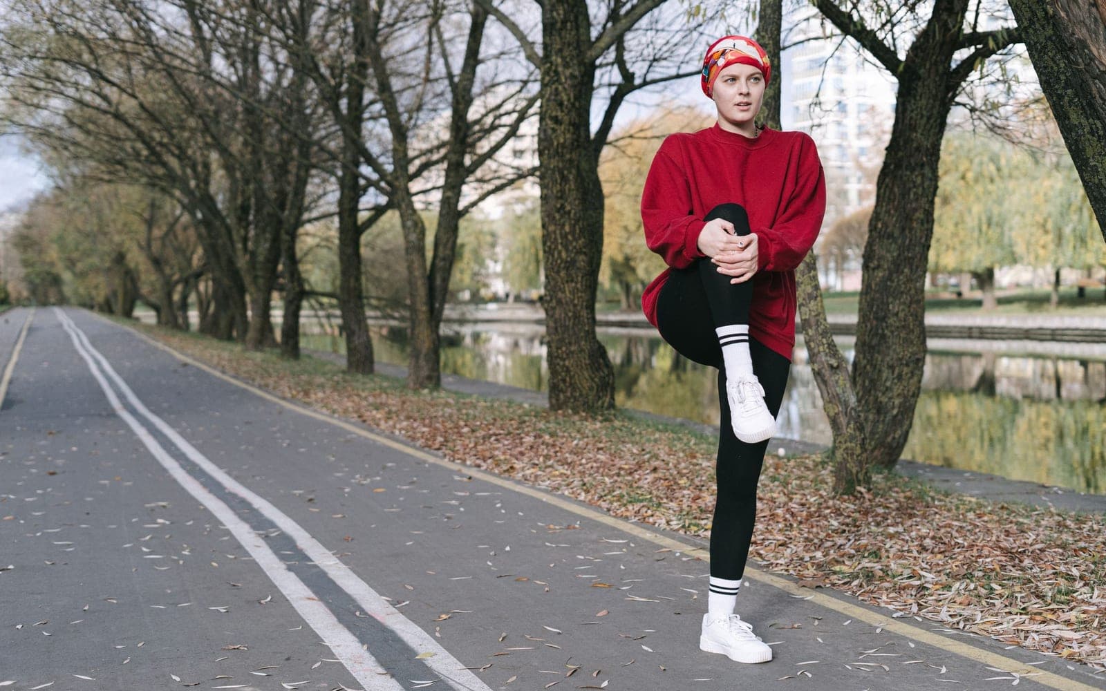 A runner stretching on a park path in winter
