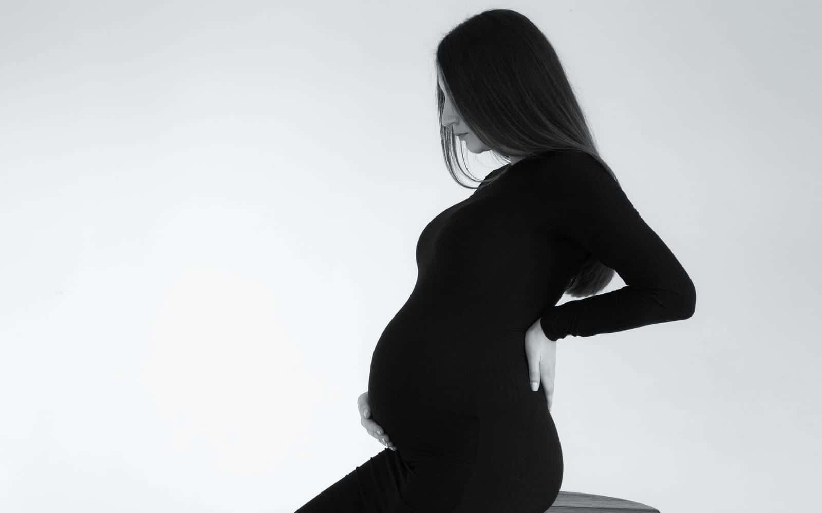A pregnant woman holding her lower back