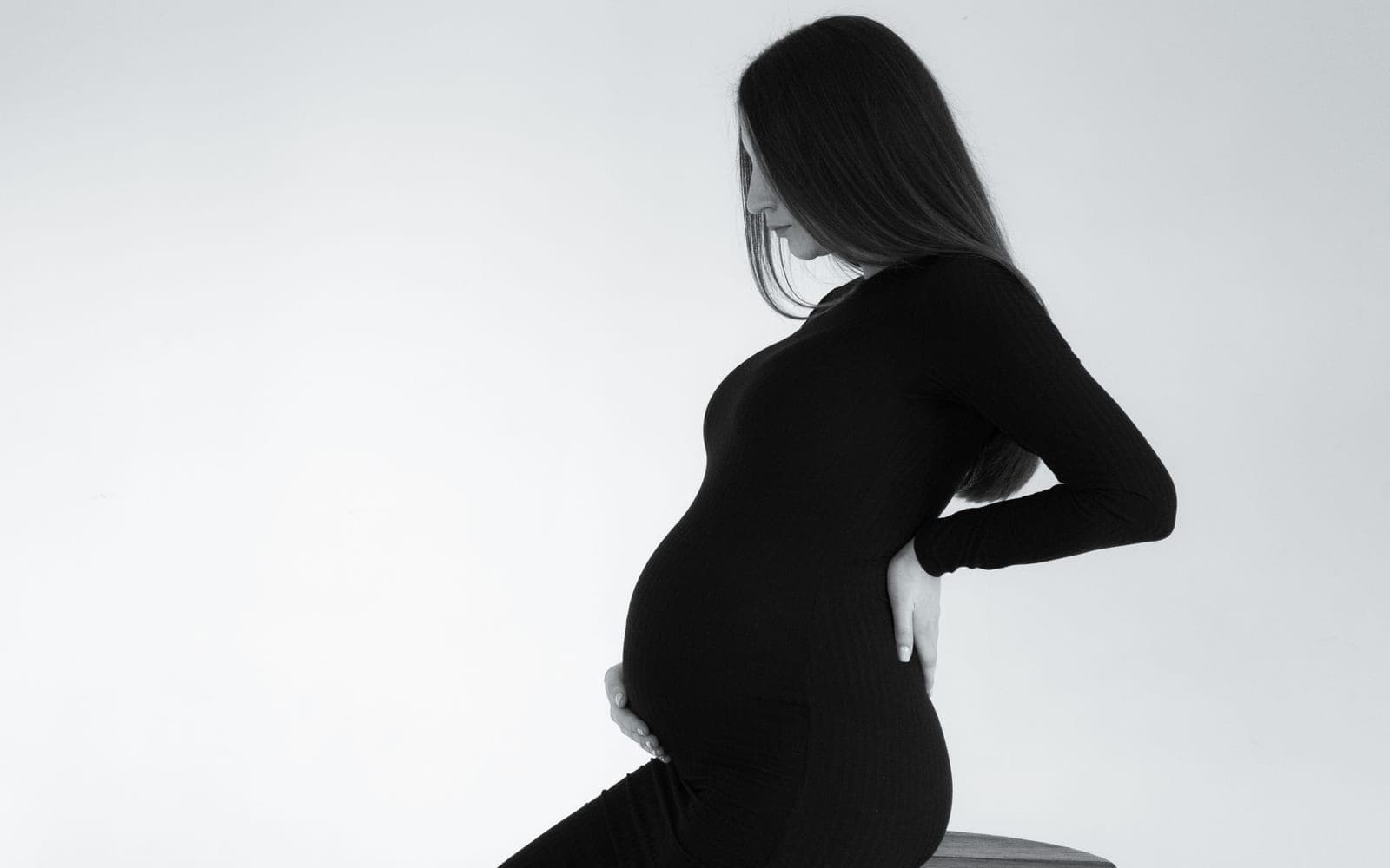 A pregnant woman holding her lower back