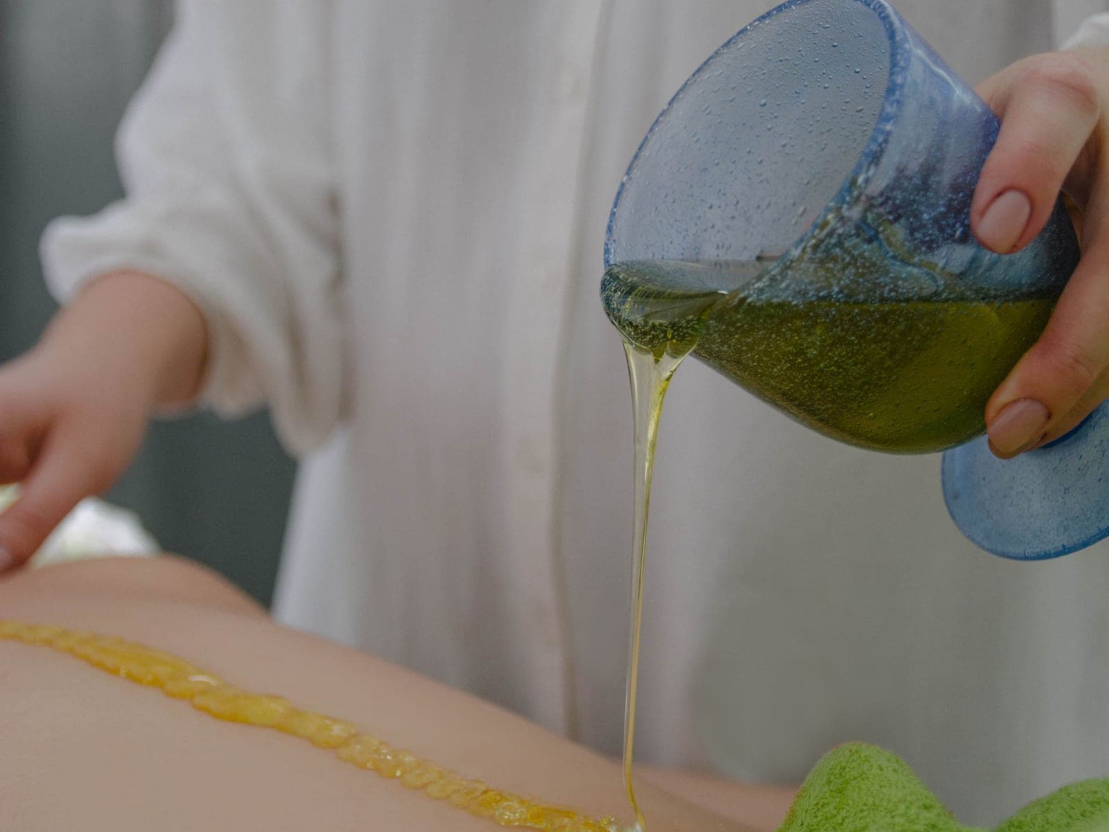 Warm oil poured in a steady stream during an Ayurvedic treatment
